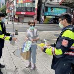 臺北市保安警察大隊員警手持宣導海報，以標語提醒民眾，小心防疫期間常見的簡訊詐騙。