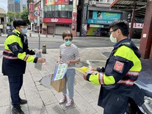 臺北市保安警察大隊員警手持宣導海報，以標語提醒民眾，小心防疫期間常見的簡訊詐騙。